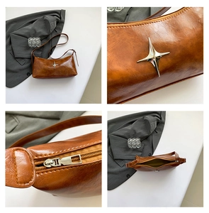 Detail view of brown leather half-moon bag with silver star ornament and zipper closure