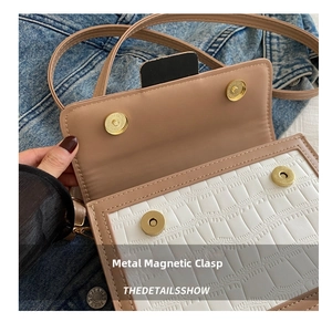 Detail der beigen Krokodilleder-Klappe mit zwei goldenen Magnet-Druckknöpfen