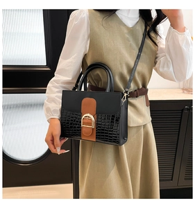 Détail de la texture cuir croco et boucle dorée sur ce sac bandoulière bicolore chic