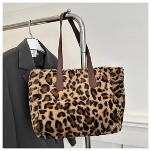 Detail of plush leopard print tote bag featuring soft faux fur and brown leather handles