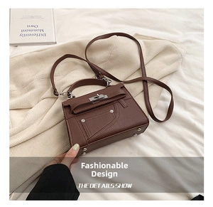Detailed view of the brown lychee grain leather texture and silver metal rotating lock