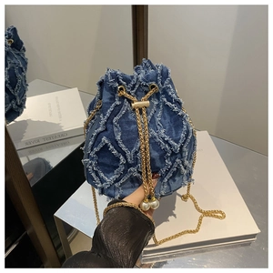 Detail der blauen Denim-Beuteltasche mit Rautensteppung, Goldketten und Perlenakzenten