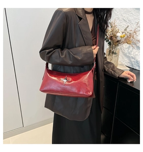 Close-up of vintage red leather shoulder bag with a silver star-shaped metal buckle