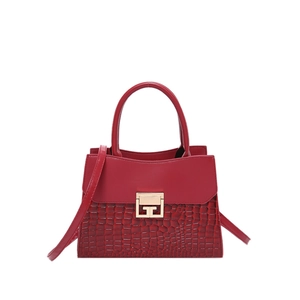 Borsa rossa con texture a coccodrillo, fibbia dorata e tracolla su sfondo bianco