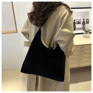 Detail of minimalist black matte suede tote bag shown in a stylish interior setting
