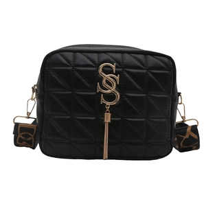 Sac bandoulière matelassé noir tendance avec bandoulière large et détails dorés sur fond blanc