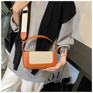 Dettaglio della borsa vintage con bordo in pelle caramello e inserto in tela beige