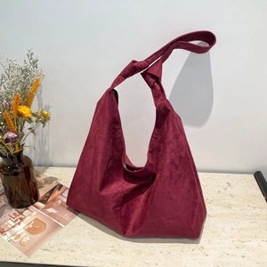 Sac cabas bordeaux en daim avec bandoulière nouée élégante sur surface en marbre