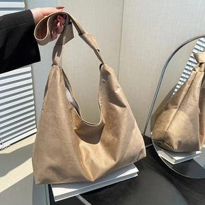 Grand sac cabas rétro en daim marron avec bandoulière nouée sur des livres blancs