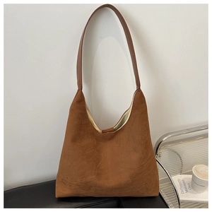 Detail view of large caramel suede hobo bag with sleek dark brown leather shoulder strap
