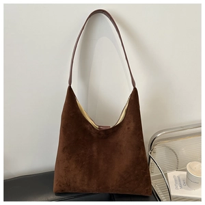 Detailed close-up of dark brown suede hobo bag with sleek shoulder strap and soft lining