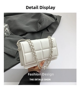 Detail view of white quilted square bag featuring silver chain strap and leather texture