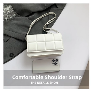 Close-up of white quilted crossbody bag with metal chain strap and phone size reference
