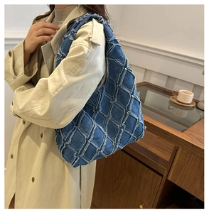 Detail of blue denim tote bag featuring quilted patch pattern and frayed edges style