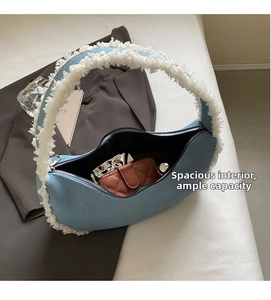 Spacious interior of denim crescent bag with white faux fur trim and zipper closure
