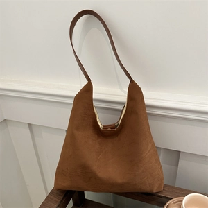 Chic brown faux suede tote bag with slim shoulder straps in a minimalist home setting