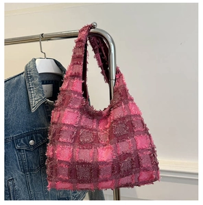 Detail of pink and purple plaid tweed tote bag with fringe texture on a metal hanger