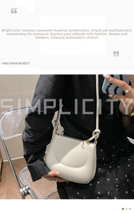 Detail view of the beige crescent shoulder bag with unique knotting on the strap and gold zipper
