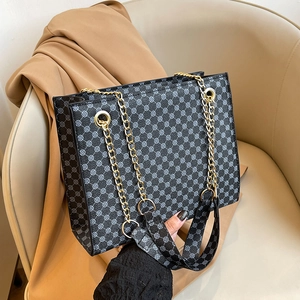 Minimalist black tote bag with geometric circular pattern and golden chain strap