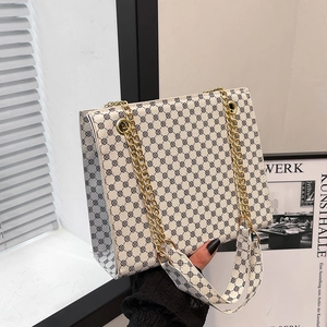 Minimalist beige crossbody tote with black geometric pattern and gold chain handles
