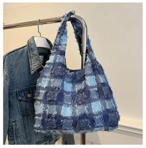 Detail of bohemian patchwork denim tote bag featuring frayed edges and vintage square patterns