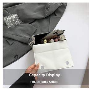 Internal view of the white square shoulder bag showing storage capacity for phone and makeup