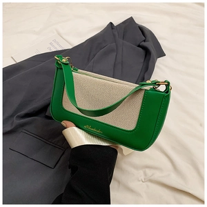 Dettaglio della borsa in pelle verde e tessuto intrecciato crema con fibbie dorate
