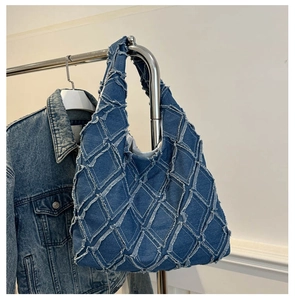 Detail of vintage denim tote bag featuring diamond frayed patchwork and dark blue texture