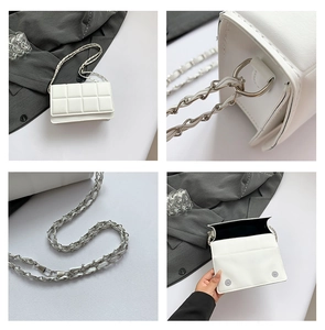Detail of white quilted leather bag with silver chain strap and metal hardware accents