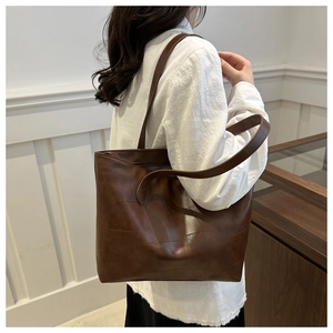 Detail shot of a dark brown tote bag with square stitching on smooth faux leather