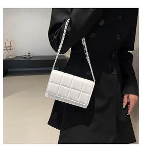 Detailed view of white quilted PU leather crossbody bag with silver woven chain strap
