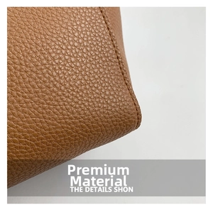 Detail shot of caramel litchi grain leather bucket bag with precise stitching
