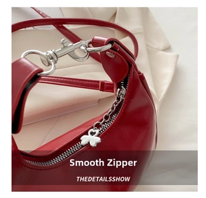 Detail of red glossy leather bag with silver heart-shaped zipper and smooth hardware