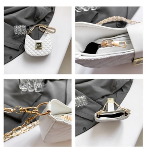 Detail of white quilted half-moon bag with gold M buckle and metallic chain strap