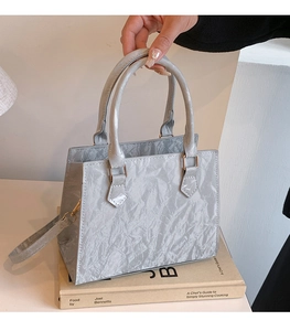 Silver wrinkled PU leather tote bag detail with golden hardware and round handles
