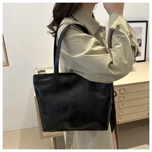 Detail of minimalist black tote bag featuring premium leather stitching and large capacity