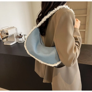 Detail of blue denim hobo bag with white faux fur trim styled with a brown blazer