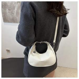 Detailed back view of white leather crescent bag with chain and clover charm