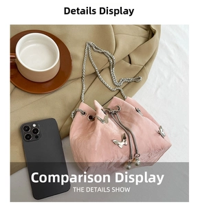 Detail view of pink ruffled drawstring bucket bag with silver butterfly and pearl charms