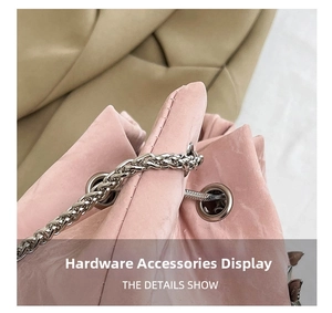 Macro detail of pink textured leather bag with polished silver eyelets and chain