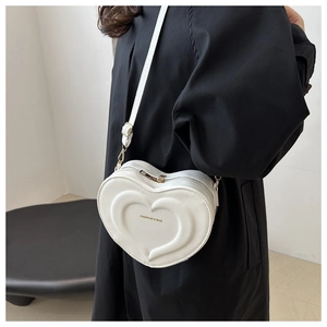 Dettaglio della borsa a tracolla bianca a forma di cuore con cerniere dorate
