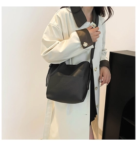 Detail of black lychee grain leather bucket bag in a slouchy minimalist style for women