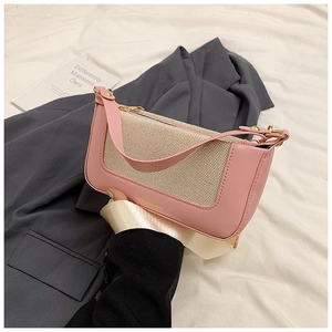 Dettaglio della borsa baguette bicolore con tessuto intrecciato beige e finiture rosa