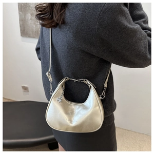 Detail of silver crescent shoulder bag with metallic leather texture and clover charm