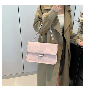 Detail of light pink chain shoulder bag with silver buckle and quilted leather texture
