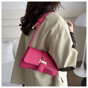 Detail of trendy rose pink crossbody bag with golden H-clasp and knotted strap detail