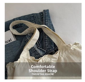 Close-up of wide comfortable shoulder strap on beige canvas tote bag with neat stitching
