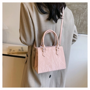 Detailed view of pink pleated tote bag with glossy finish and detachable shoulder strap