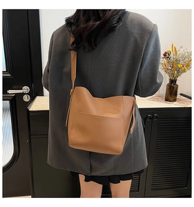 Close-up of caramel brown pebble leather tote bag featuring a soft texture and wide strap
