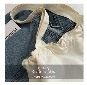 Detail of reinforced shoulder strap stitching on a white nylon tote shopping bag